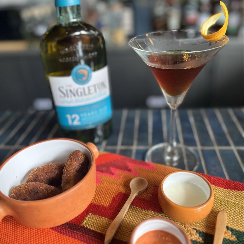 Plato croquetas de pollo y champiñones acompañado con  el cóctel  Rob Roy