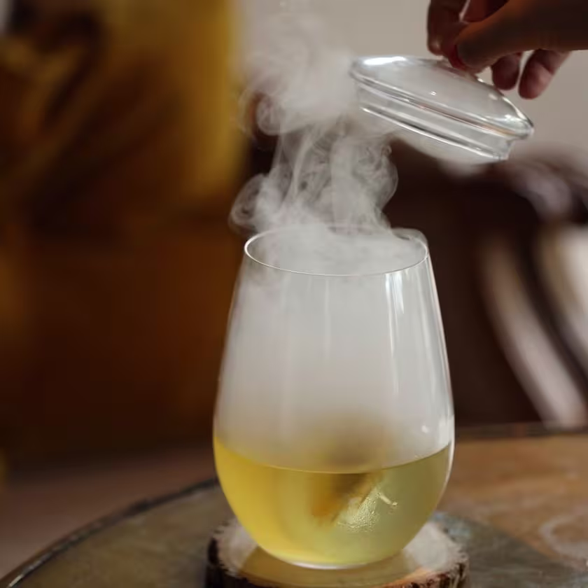 Vaso de cóctel con humo saliendo en la parte superior.