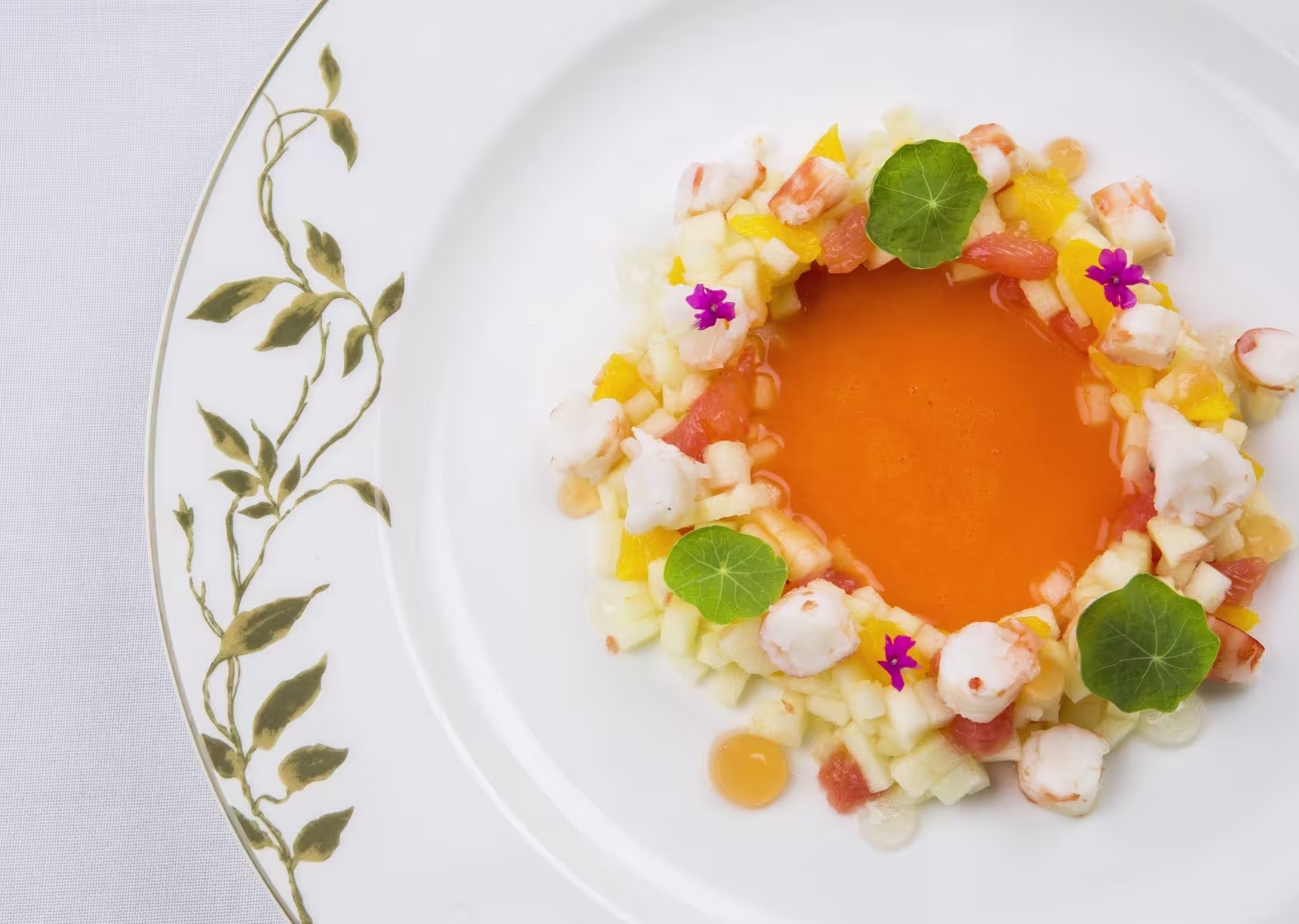 En el restaurante Solc del Majestic Hotel, un plato de gazpacho con frutas frescas y langostinos destaca por su elegancia y frescura visual.