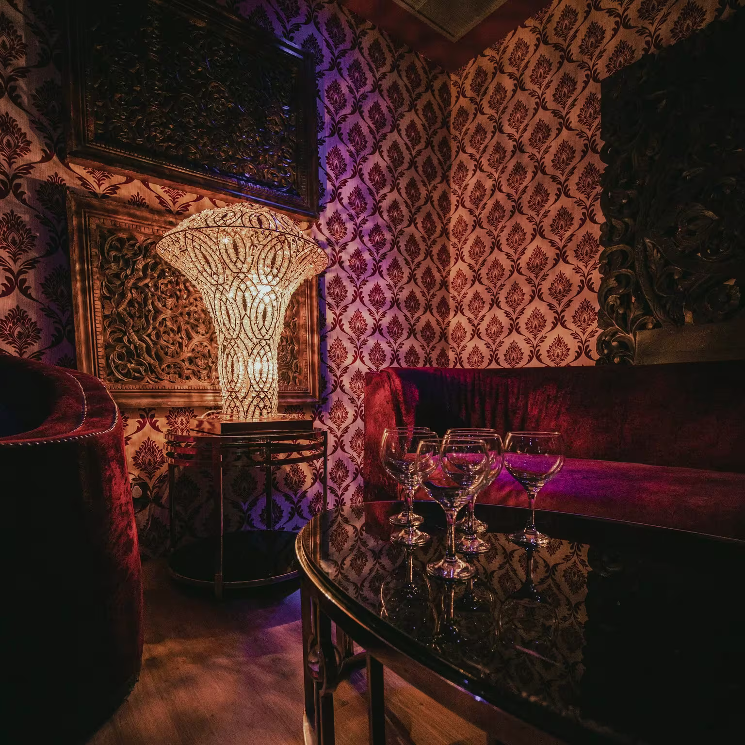 Kumarah con decoración lujosa, lámpara artesanal y sofás de terciopelo, un espacio íntimo ideal para noches exclusivas y elegantes.