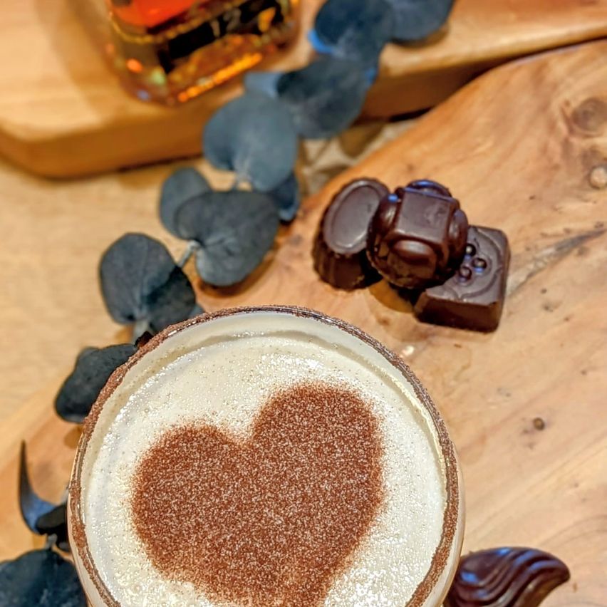 Vaso de whisky acompañado de chocolates.