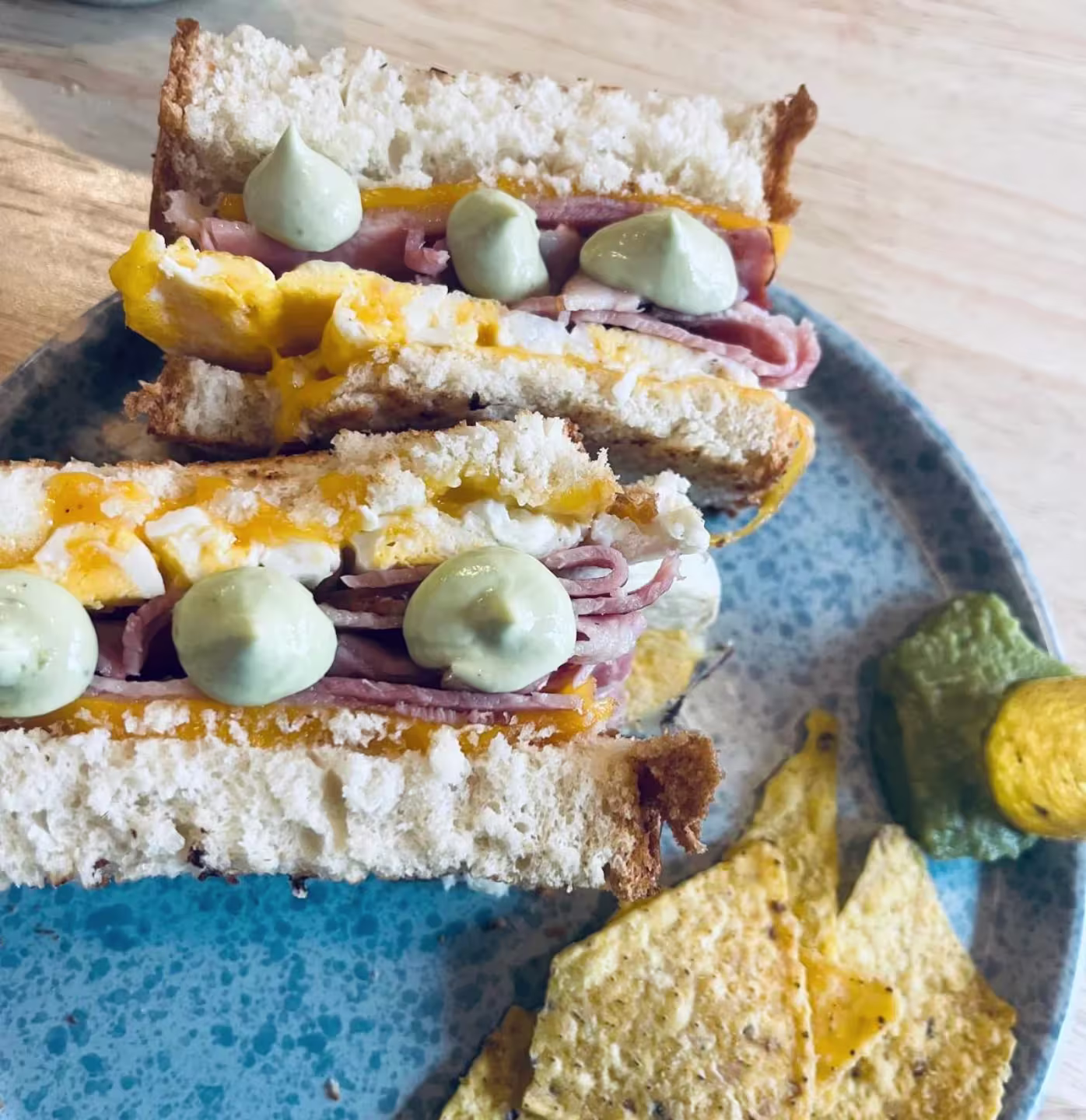 Pan crujiente, huevo, embutido y toques de crema verde: el sándwich de Purita viene con todo y nachos para acompañar.