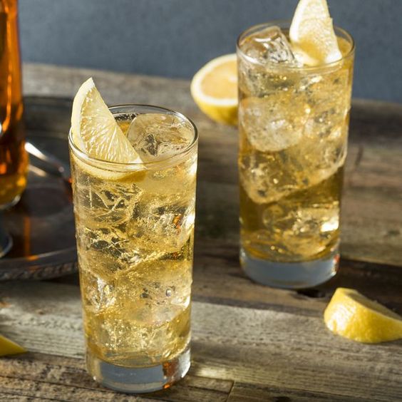2 glasses of Whisky Highball on a brown table with slices of lemons in