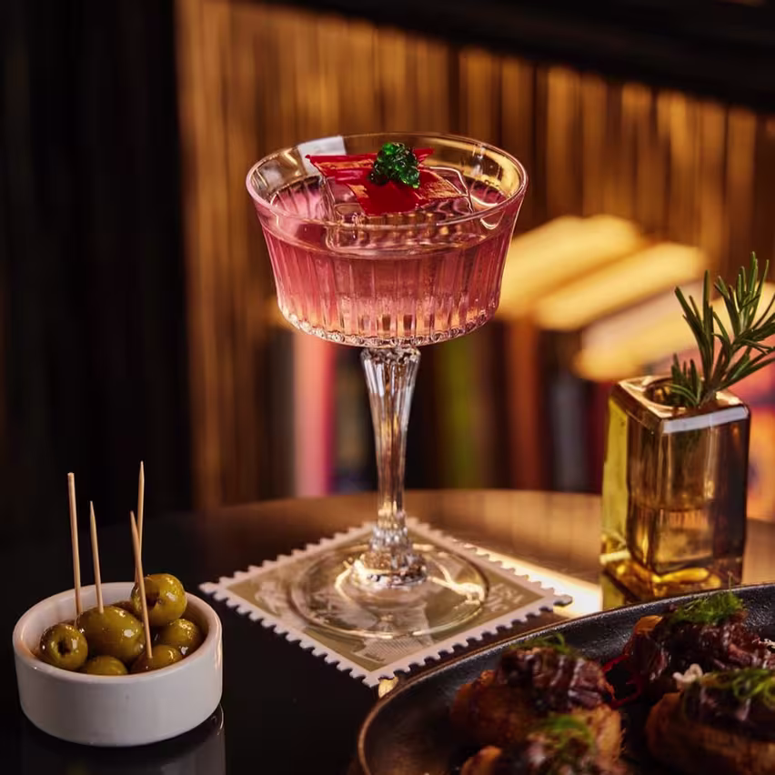 Mesa con un cóctel y un aperitivo
