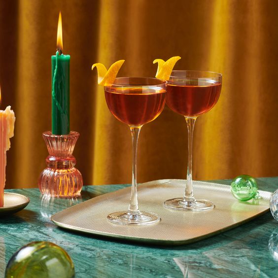 Dos copas de whisky con una rodaja de naranja.
