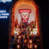 La imagen muestra en detalle un altar de la fiesta, caracterizado como la etiqueta de la botella de vodka Smirnoff Spicy Tamarind.