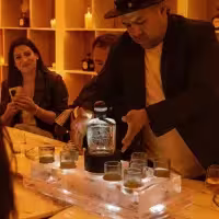 Hombre exhibiendo una botella de Tequila Don Julio