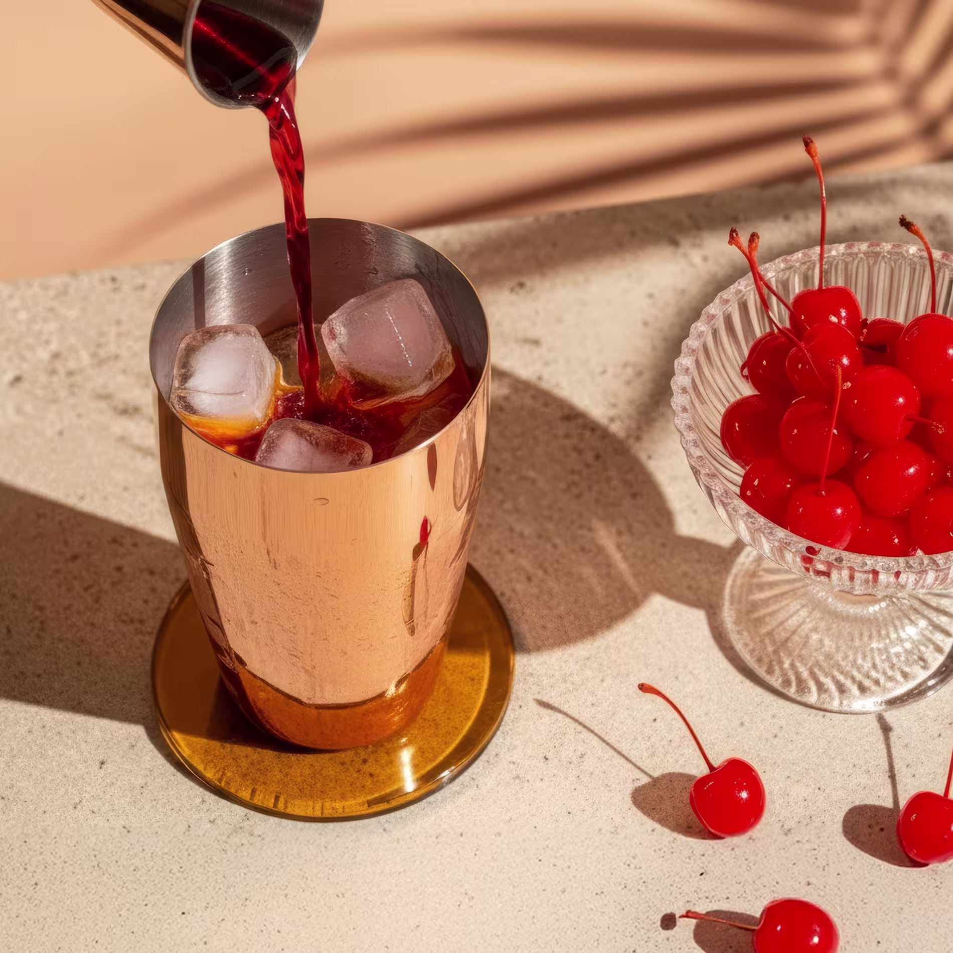 Színes folyadékokat öntenek egy réz koktélkeverőbe.