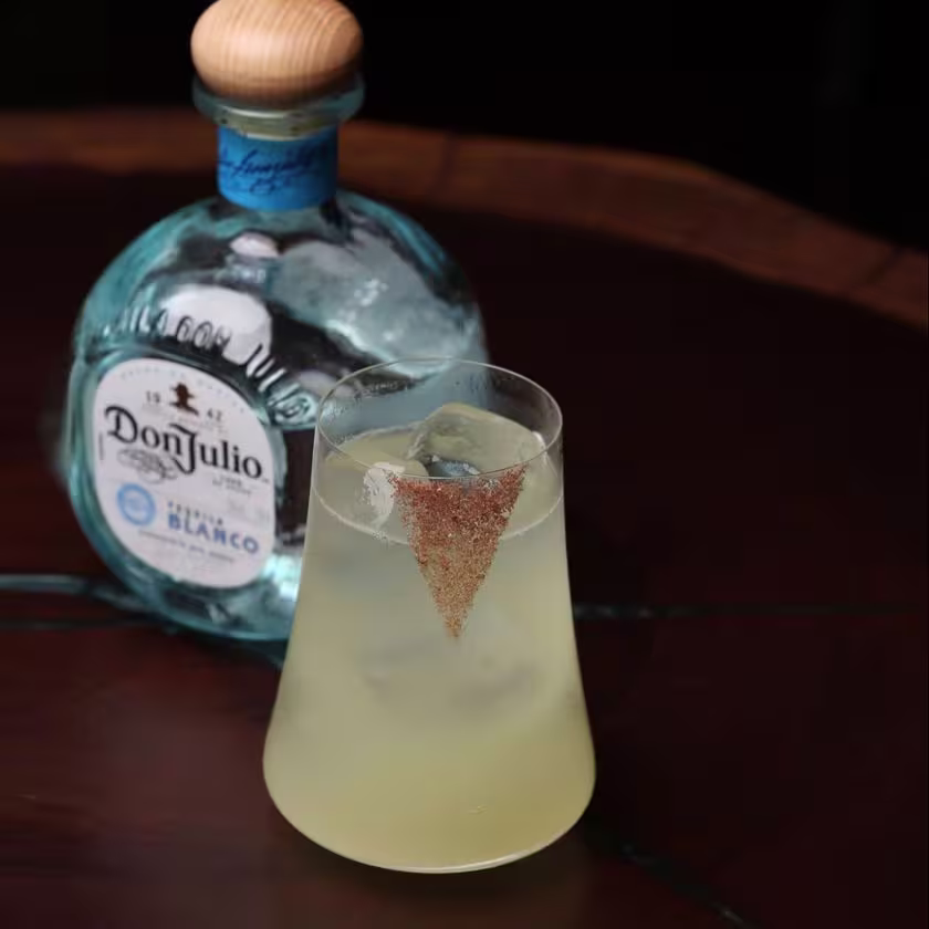 La imagen muestra una botella de Tequila Don Julio Blanco junto a un vaso lleno con el cóctel "It's Showtime".