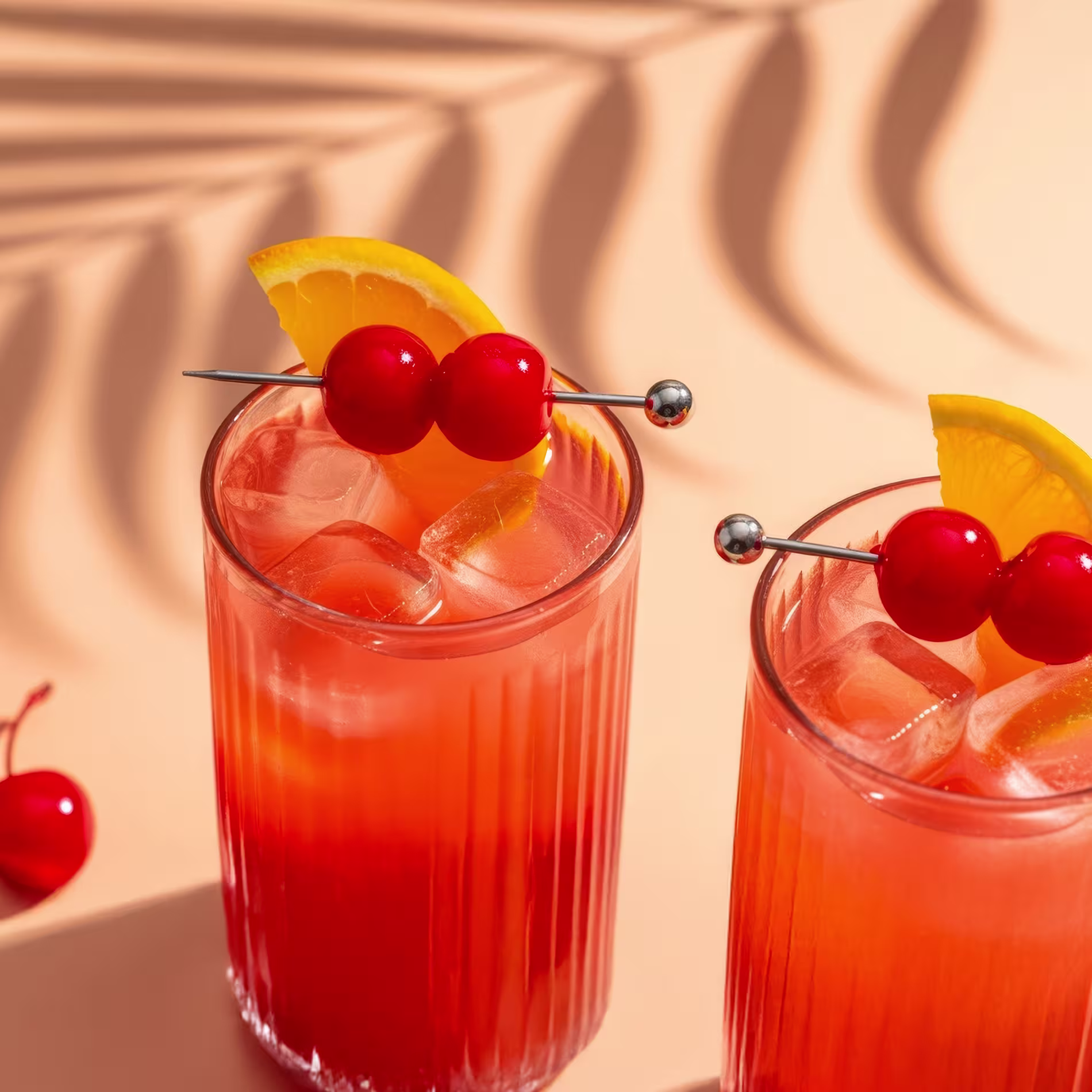 Két Sex on the Beach koktél narancs és cseresznye díszítéssel