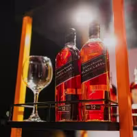 En la imagen se pueden observar dos botellas de Johnnie Wlaker Black Label con una copa