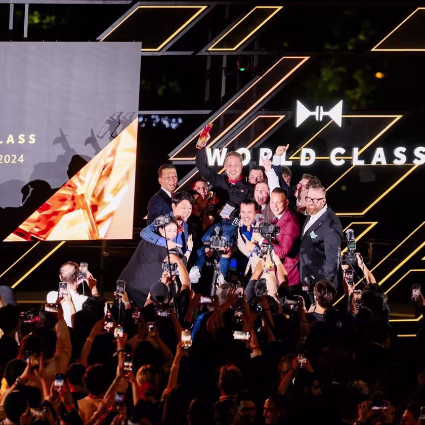 En la imagen se ve una multitud de gente, el escenario y el cartel de World Class con los ganadores siendo fotografiados en el escenario.
