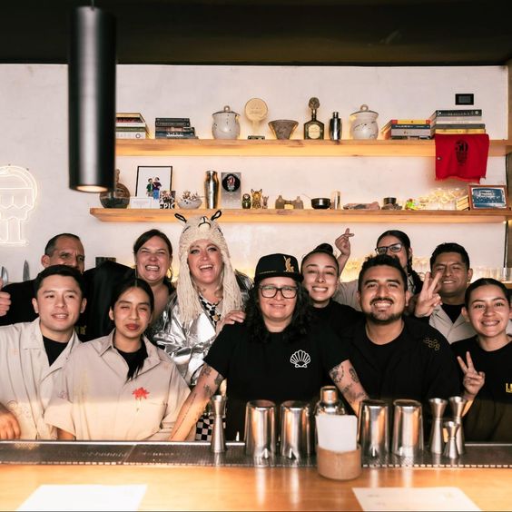 En la imagen se ve un grupo de gente que participó del evento detrás de la barra.