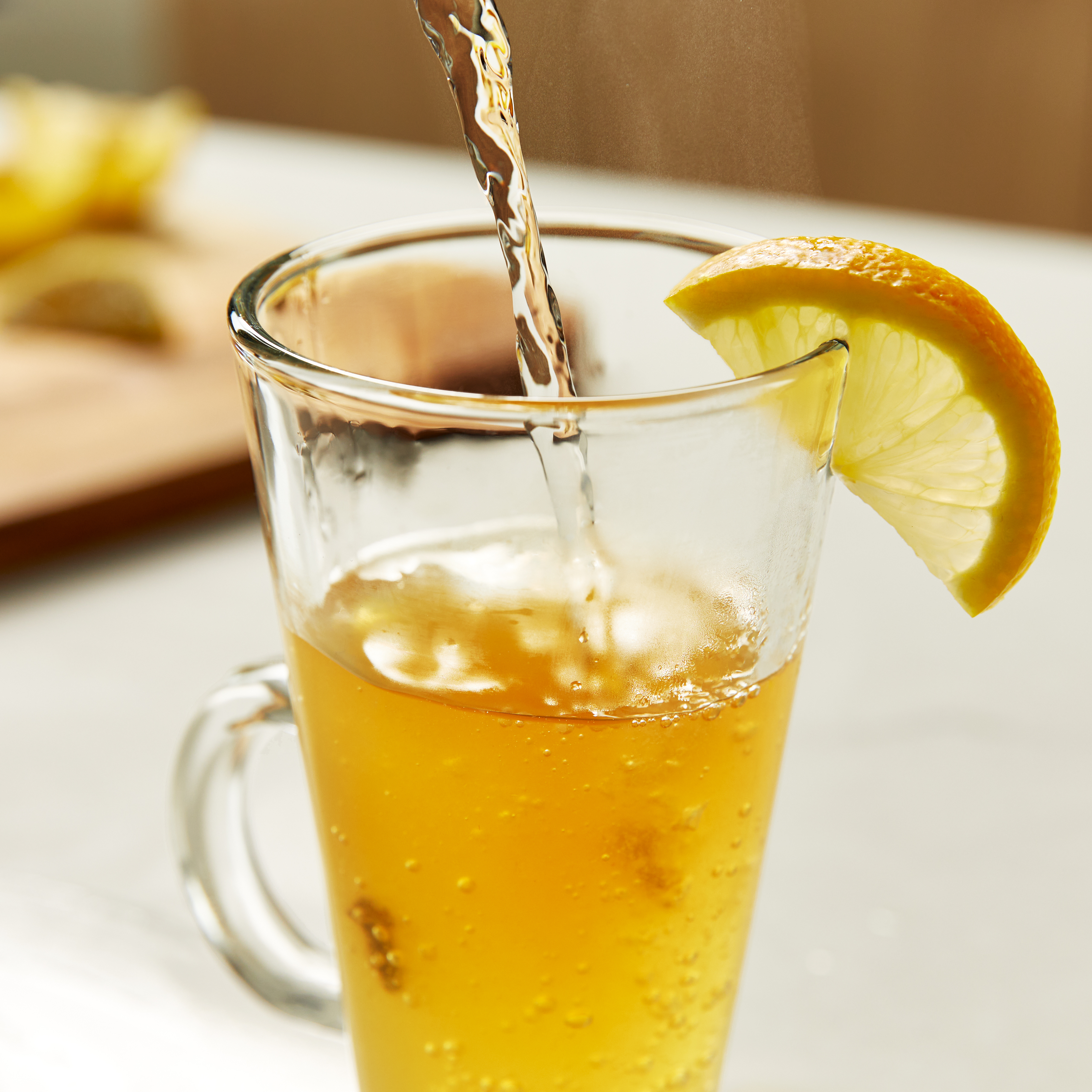 Pouring hot broth into a heatproof glass