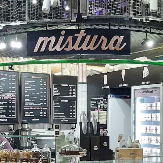 Mostrador de Mistura en el Mercado de San Antón con carta visible, expositores de producto y decoración industrial bajo el cartel de la marca.