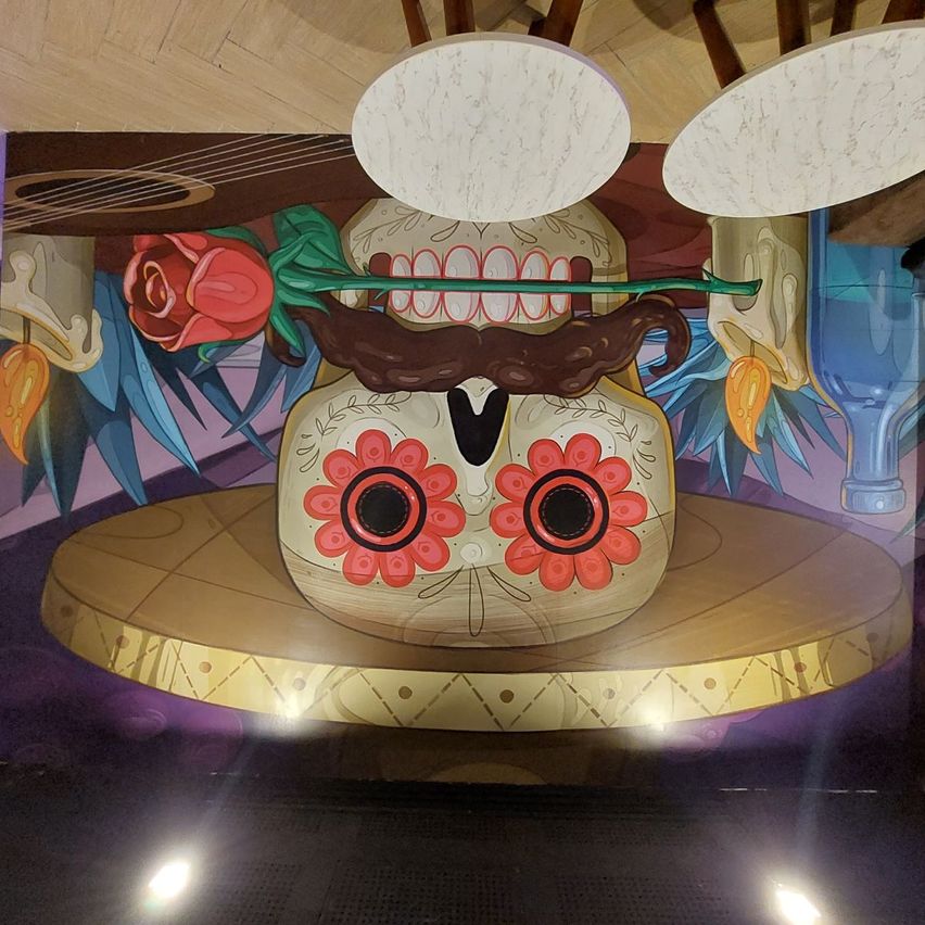 En la imagen se ve un mural del estilo mexicano que se encuentra como decoración en el bar Rosa Mezcal.