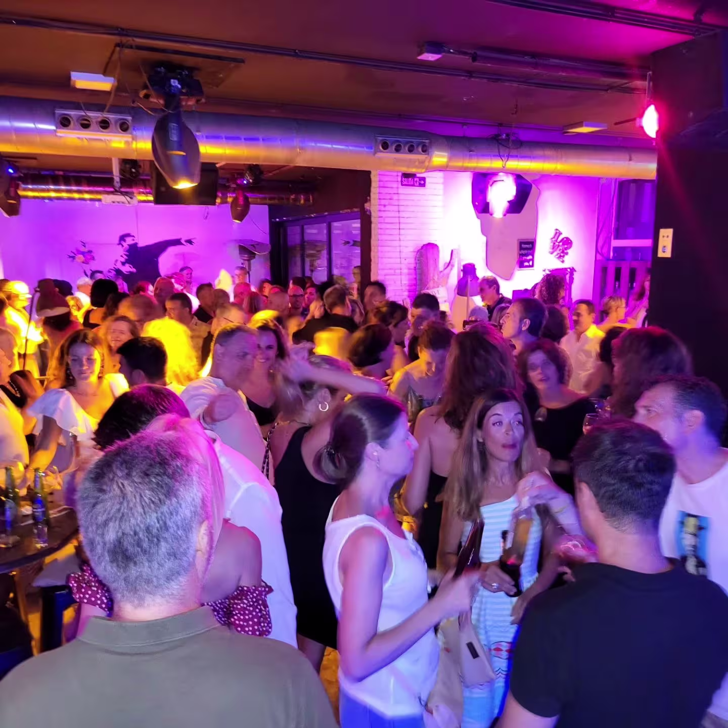 Quitapenas: Un ambiente vibrante y lleno de energía, donde las personas disfrutan de la música y la fiesta en un espacio colorido y dinámico. Ideal para quienes buscan un lugar animado para socializar y bailar.