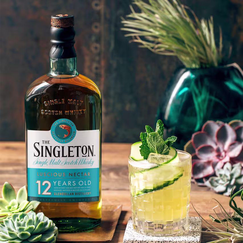 La imagen muestra una botella del whisky The Singleton 12 años junto a un vaso relleno con el cóctel Maid in Scotland.