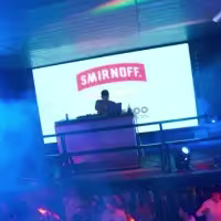 DJ tocando mientras la gente baila en la pista