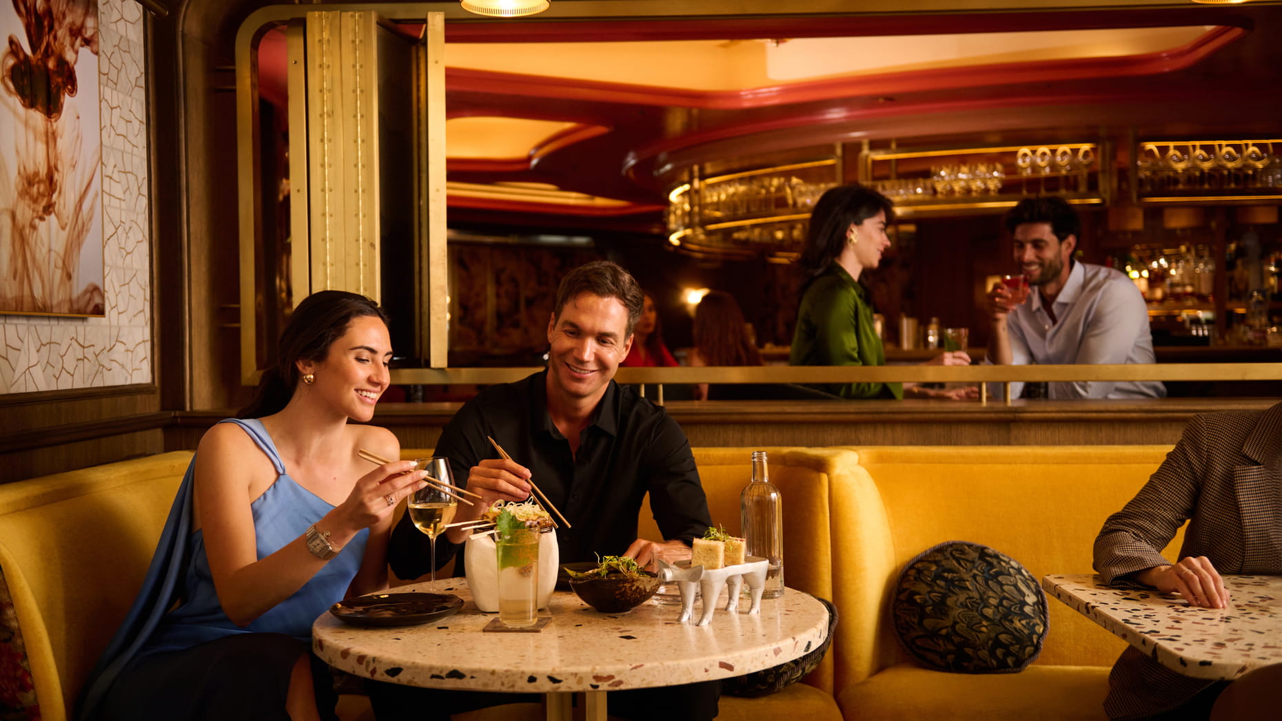 Pareja disfrutando de una cena en Isa Restaurant & Bar, con platos exóticos, cócteles y un ambiente elegante y acogedor.