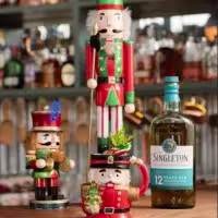 En la imagen se ven unos muñecos navideños acompañando la botella de Singleton.