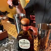 Bartender preparando un cóctel con una botella de tequila Don Julio