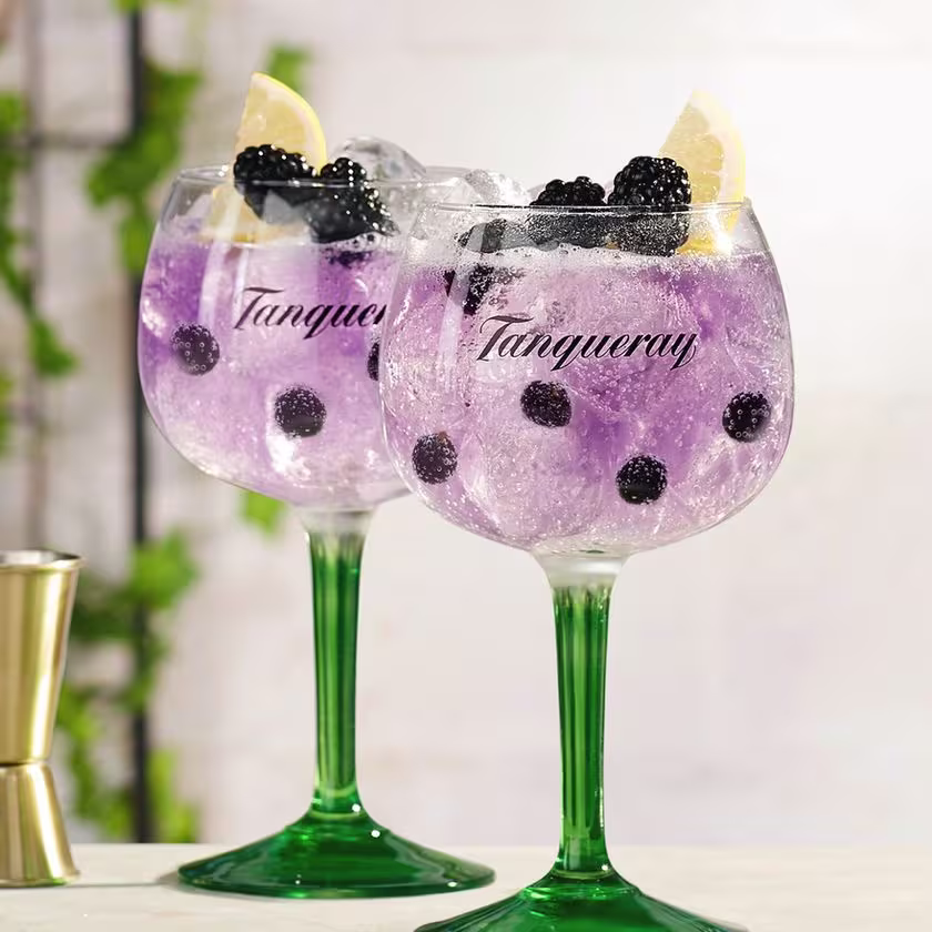La imagen muestra dos copas con cócteles preparados con Gin Tanqueray Royale.