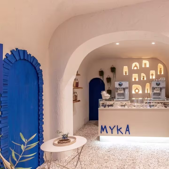 Arcos encalados, suelo de piedra y detalles azules vibrantes en el interior mediterráneo de Myka Ponzano.