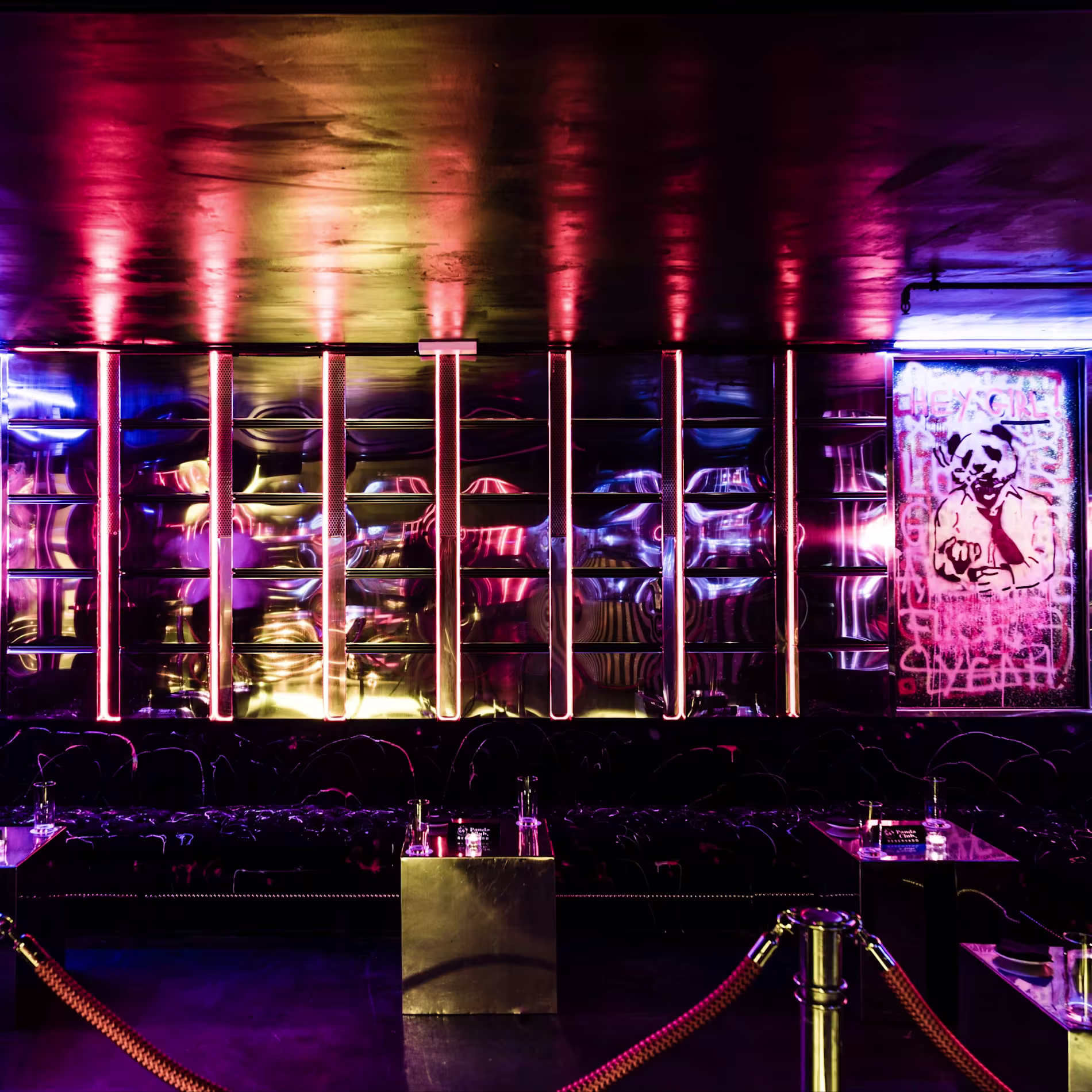 Panda Club: Espacio de atmósfera urbana y alternativa, decorado con neones en tonos morados y rojos, graffiti en las paredes y detalles metálicos, ofreciendo un ambiente moderno y vanguardista para disfrutar la noche.