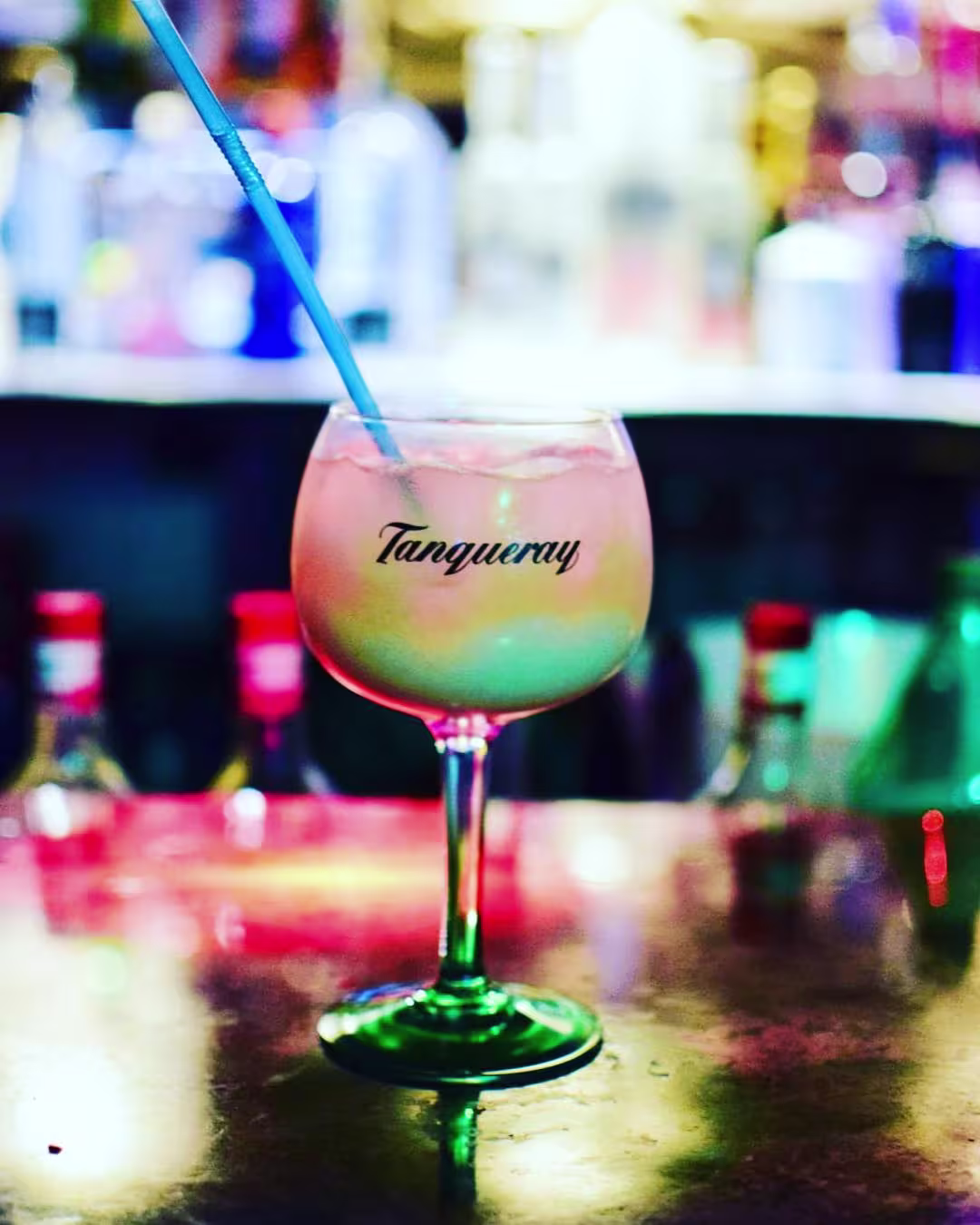 Parkim Bar con una copa de cóctel Tanqueray sobre una barra iluminada, perfecto para noches refrescantes y llenas de sabor.