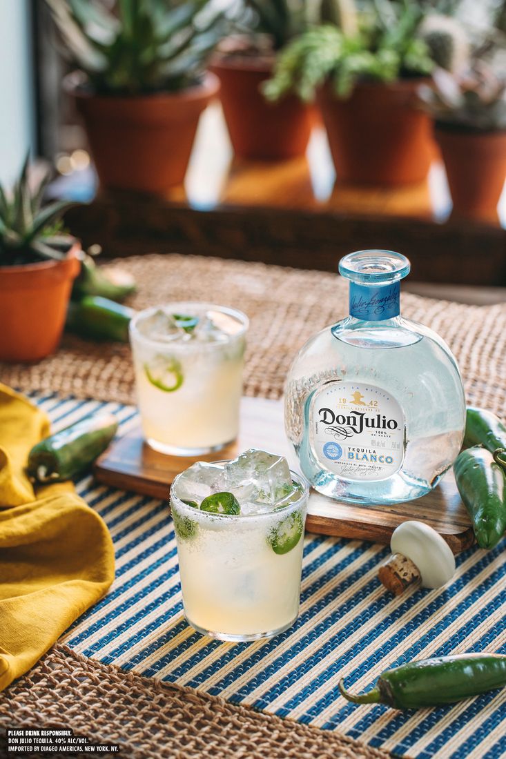 La imagen muestra una botella de tequila Don Julio Blanco y dos vasos de cócteles Margarita.