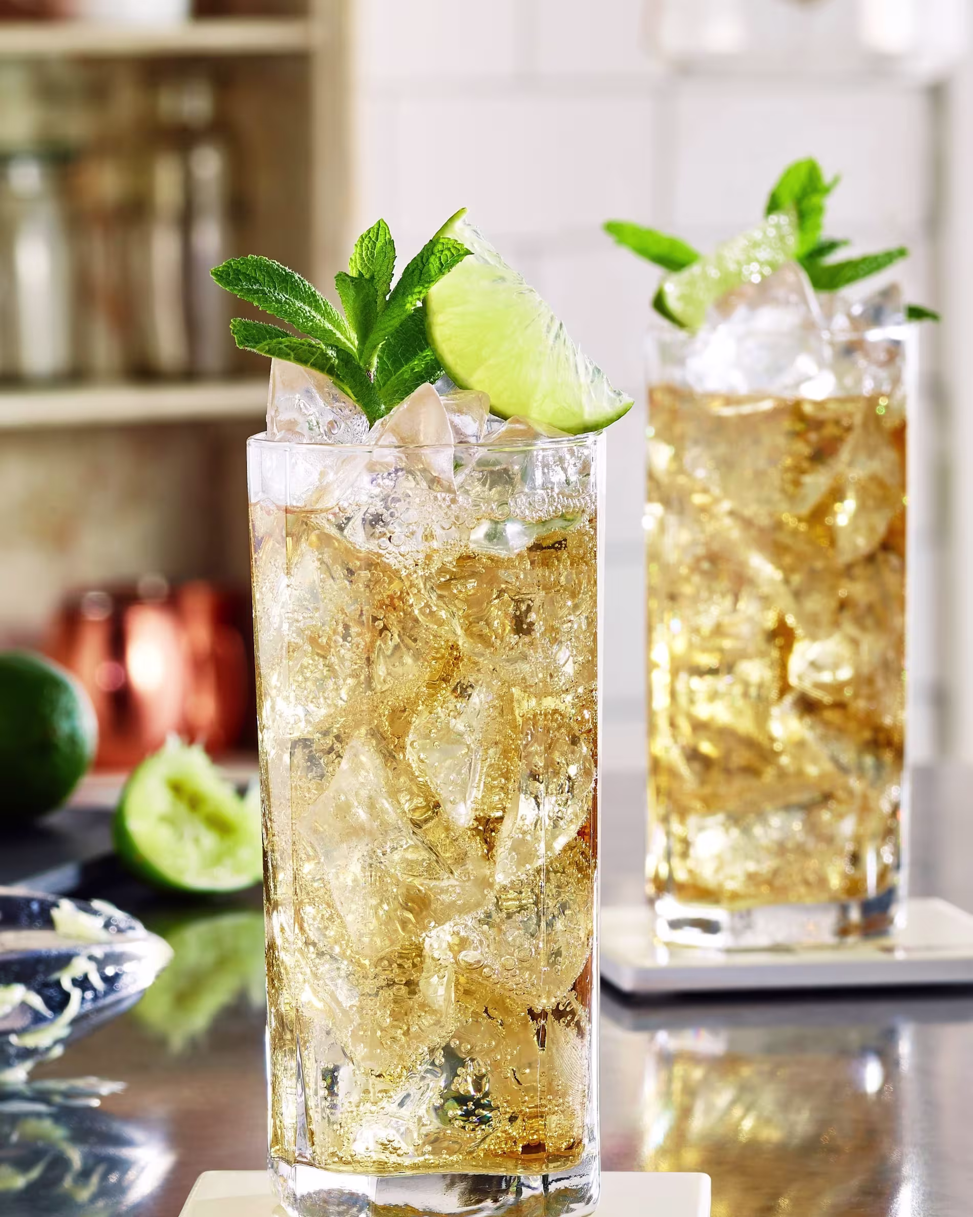 Two Dutch Mule cocktails with mint sprig and lime wedge garnishes.