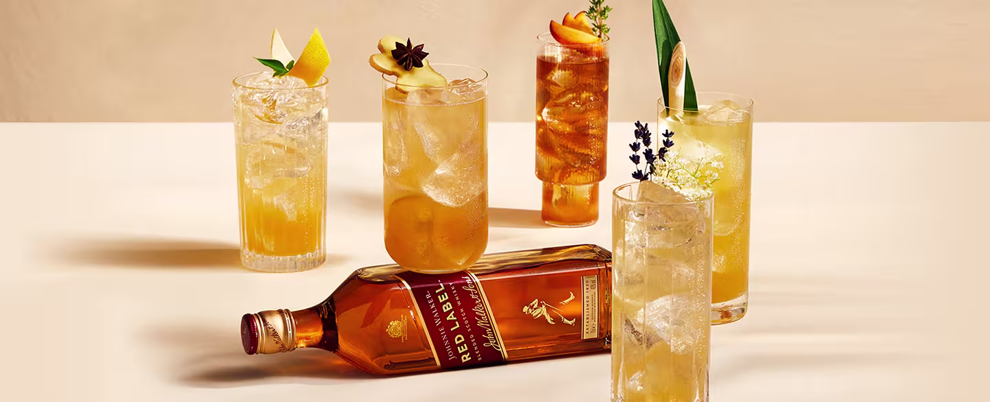 Johnnie Walker Red Label bottle with an assortment of tropical cocktails