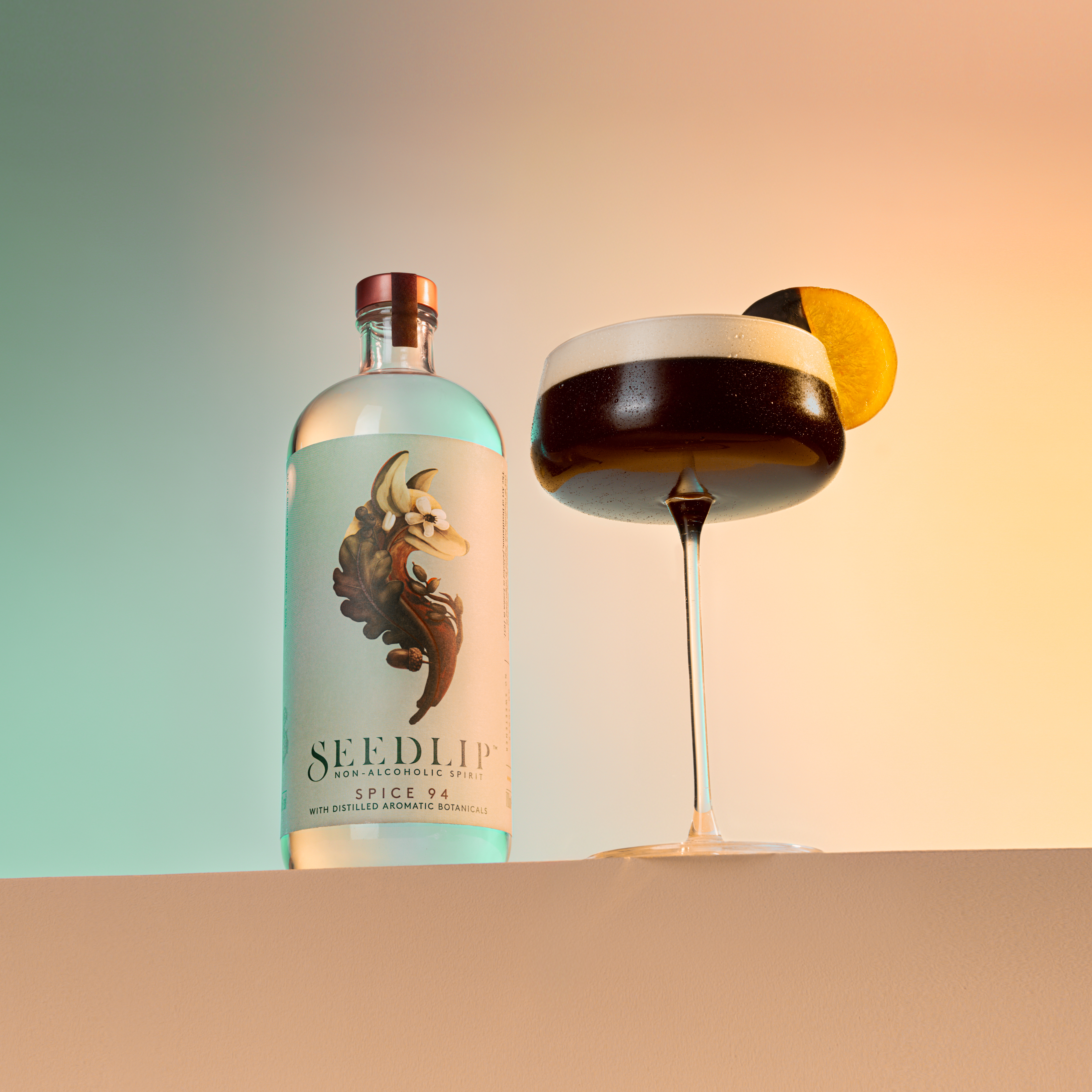 A frothy Espresso Martini cocktail with a a chocolate orange garnish next to a bottle of Seedlip. 