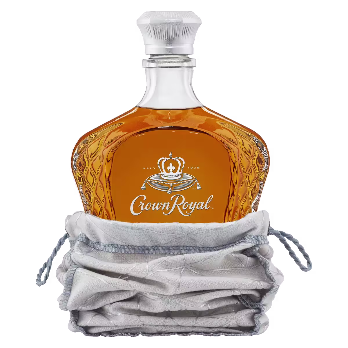 A bottle of Crown Royal whisky in a decorative glass bottle, partially wrapped in a silver drawstring pouch.