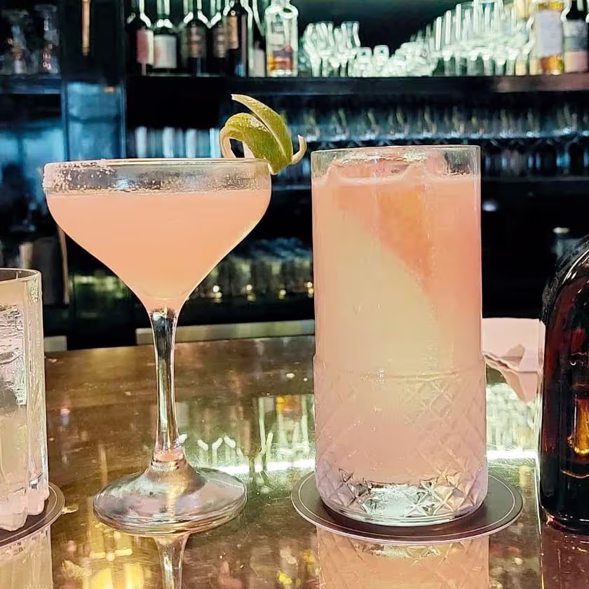 3 vasos distintos de cócteles y la botella de Don Julio Reposado. De fondo la barra del bar.