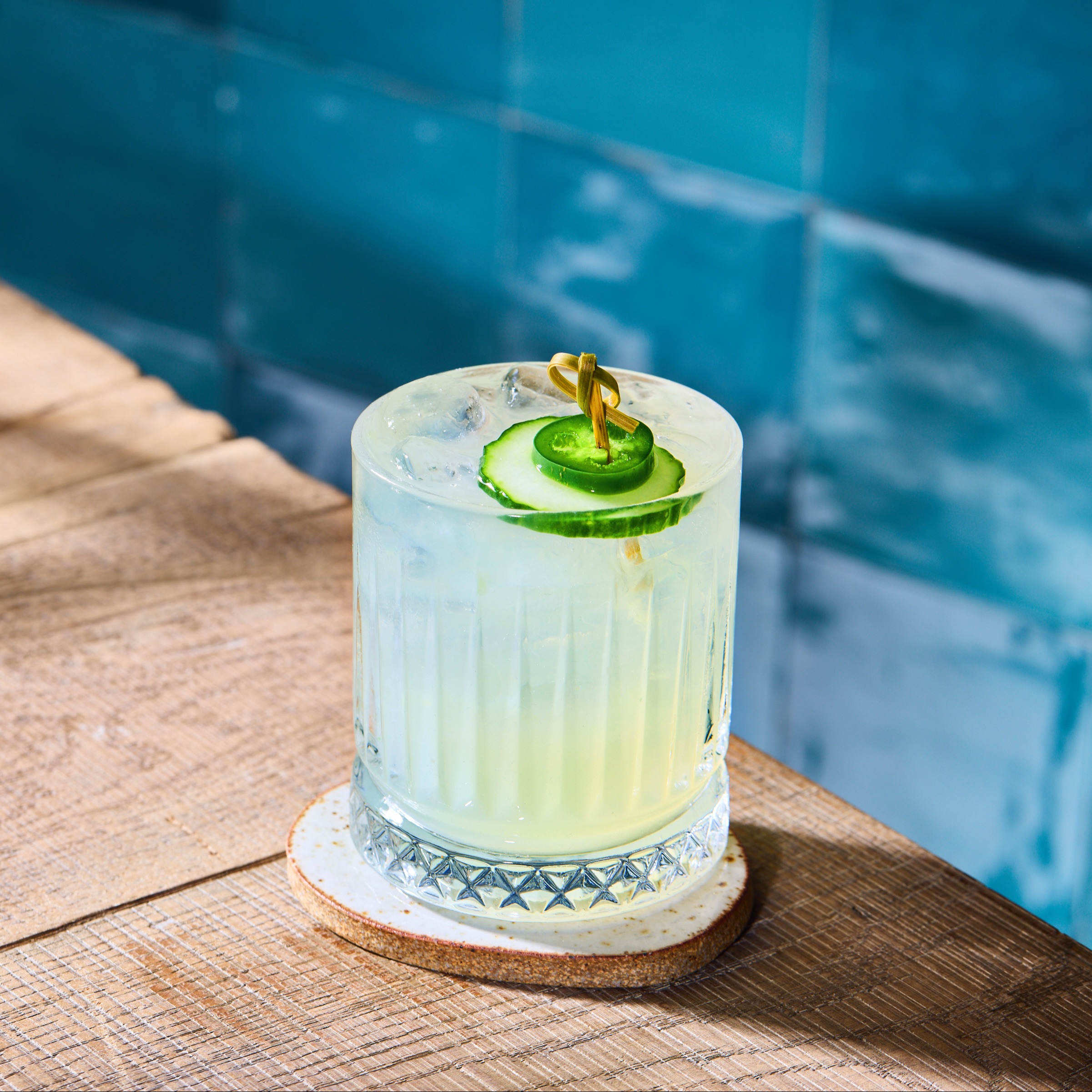 O margarita picantă cu o garnitură de castravete și chili într-un pahar cu gheață.