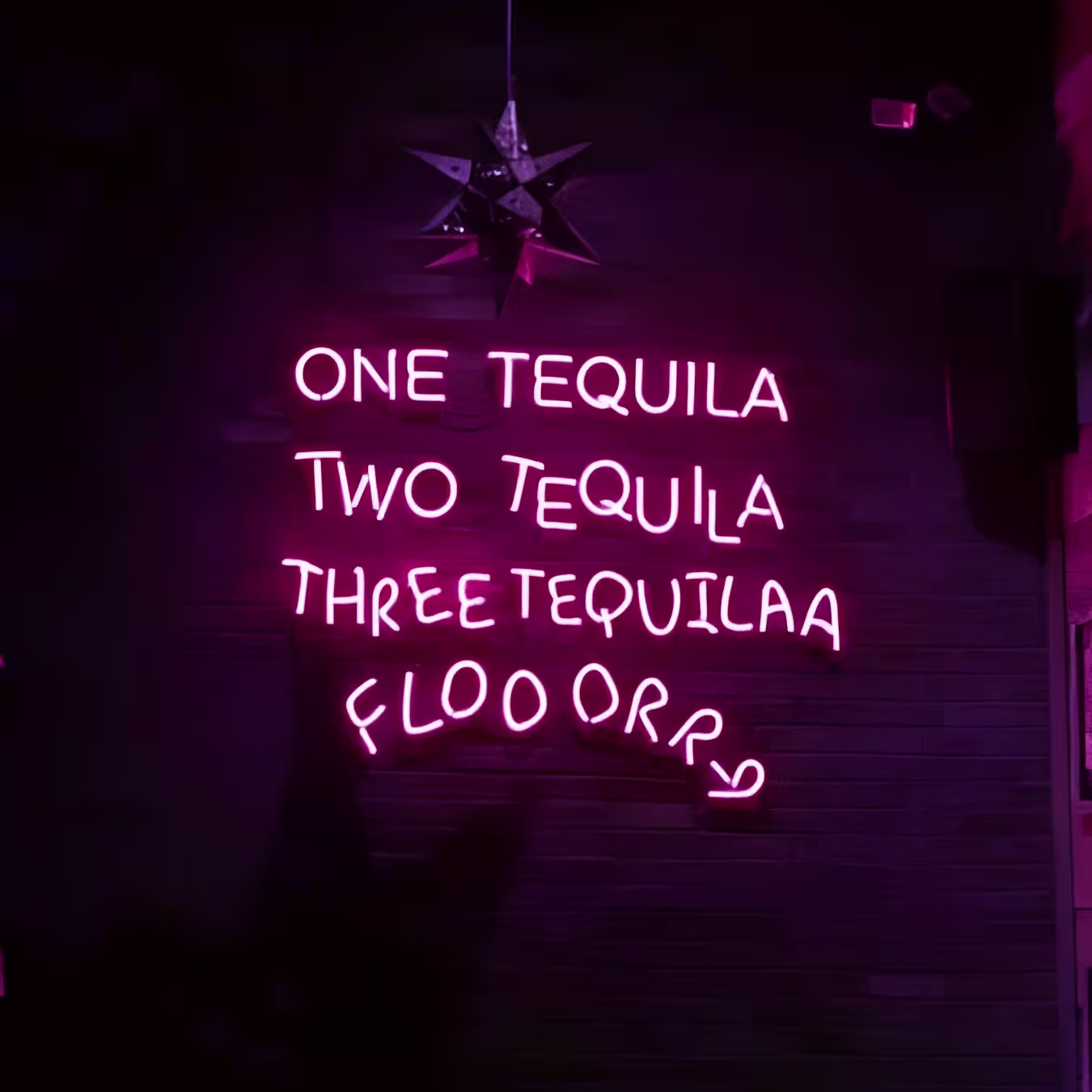 Neón rosa en Mobsters con la frase humorística: "One tequila, two tequila, three tequila, floorrr."