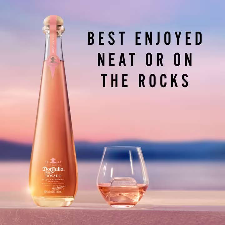 The image features a bottle of Don Julio Rosado tequila and a glass with tequila on the rocks, set against a serene sunset backdrop. The text reads: "Best Enjoyed Neat or On The Rocks," highlighting the preferred ways to savor this tequila.