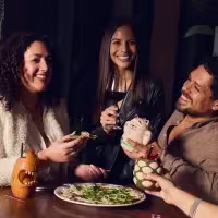 Tres amigos tomando tragos en un bar