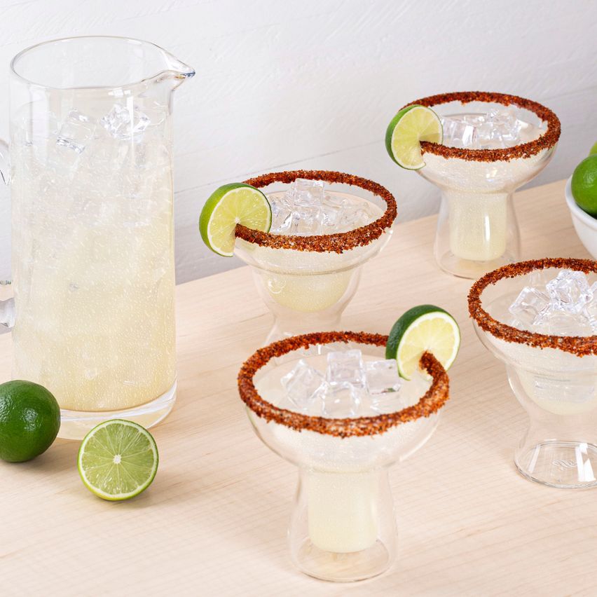 La imagen muestra una jarra y copas rellenas con el cóctel Spicy Margarita.