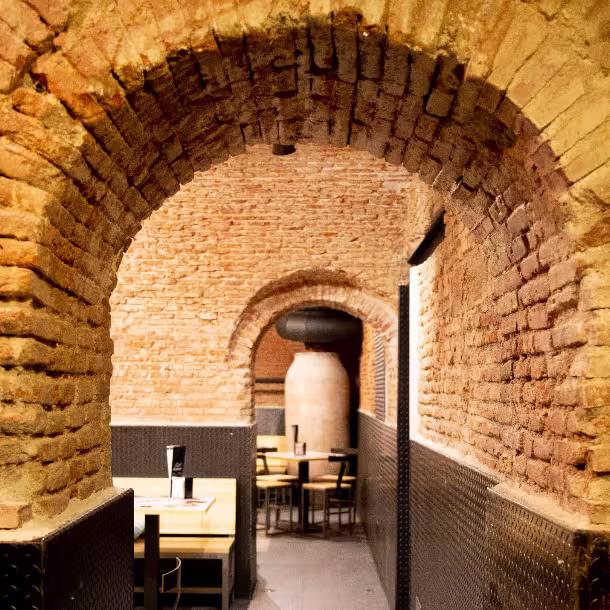 Pasillos de ladrillo abovedado y rincones con encanto en Viena Capellanes Bordadores. Un refugio cálido bajo tierra para disfrutar con calma.