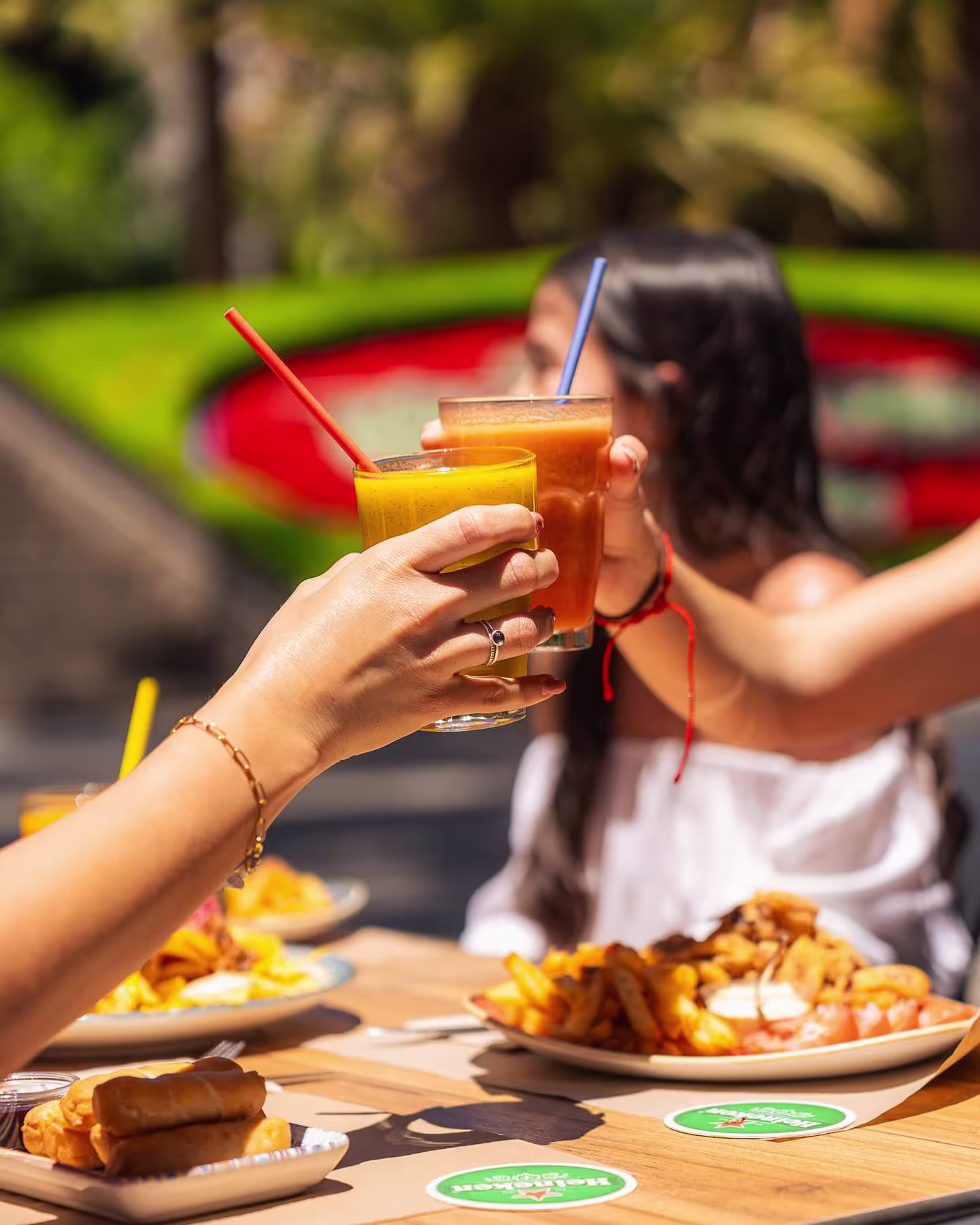 Terraza Parque con un brindis refrescante bajo el sol, acompañado de comida deliciosa y un ambiente relajado al aire libre.