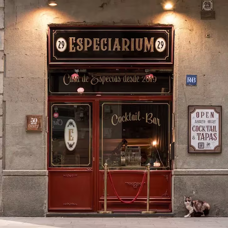 Un cocktail bar con alma de botica antigua y un gato curioso que da la bienvenida desde la acera.