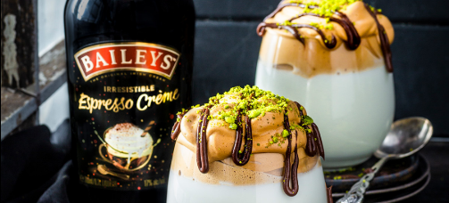 Dos postres en vasos de vidrio, Botella de Baileys Espresso creme a su izquierda.
