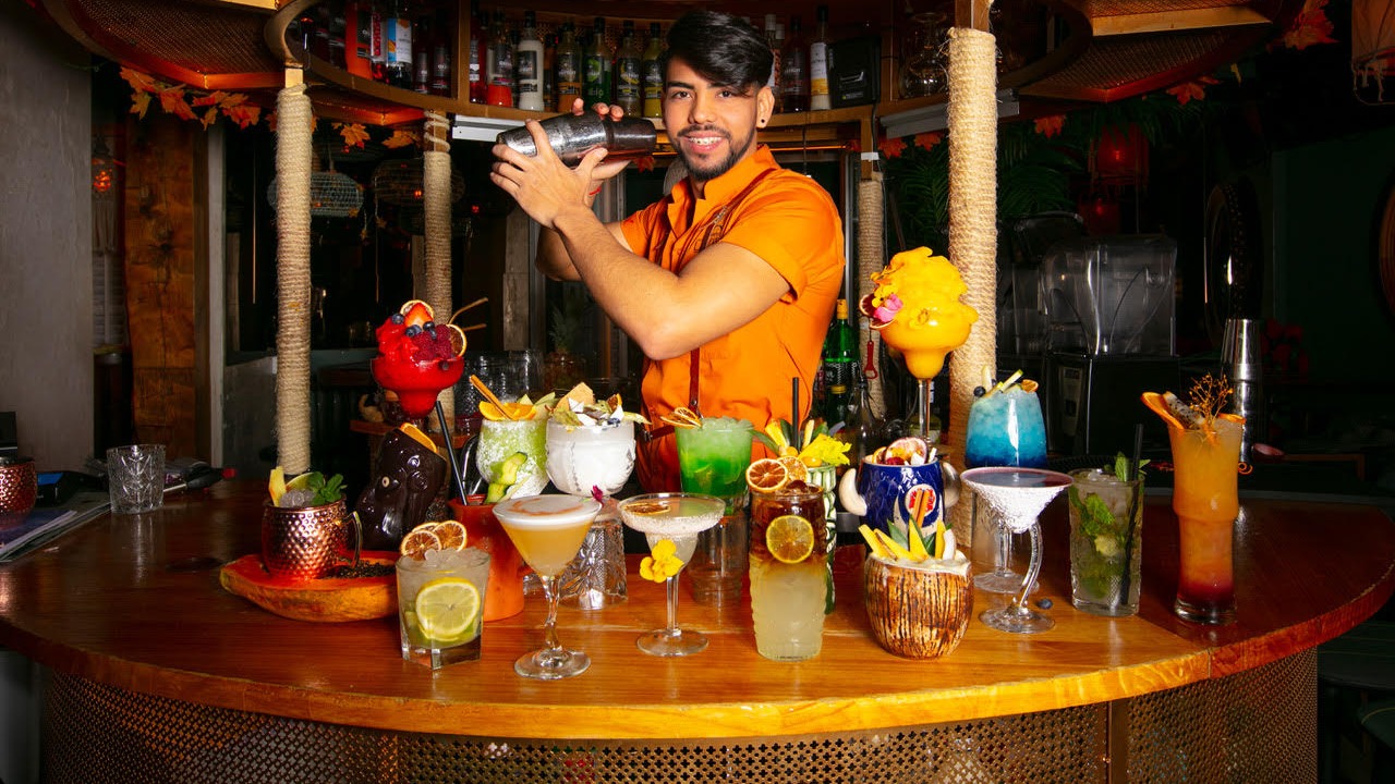 El bartender de La Kama Café despliega su arte entre cócteles coloridos y un ambiente tropical que invita a brindar y disfrutar.