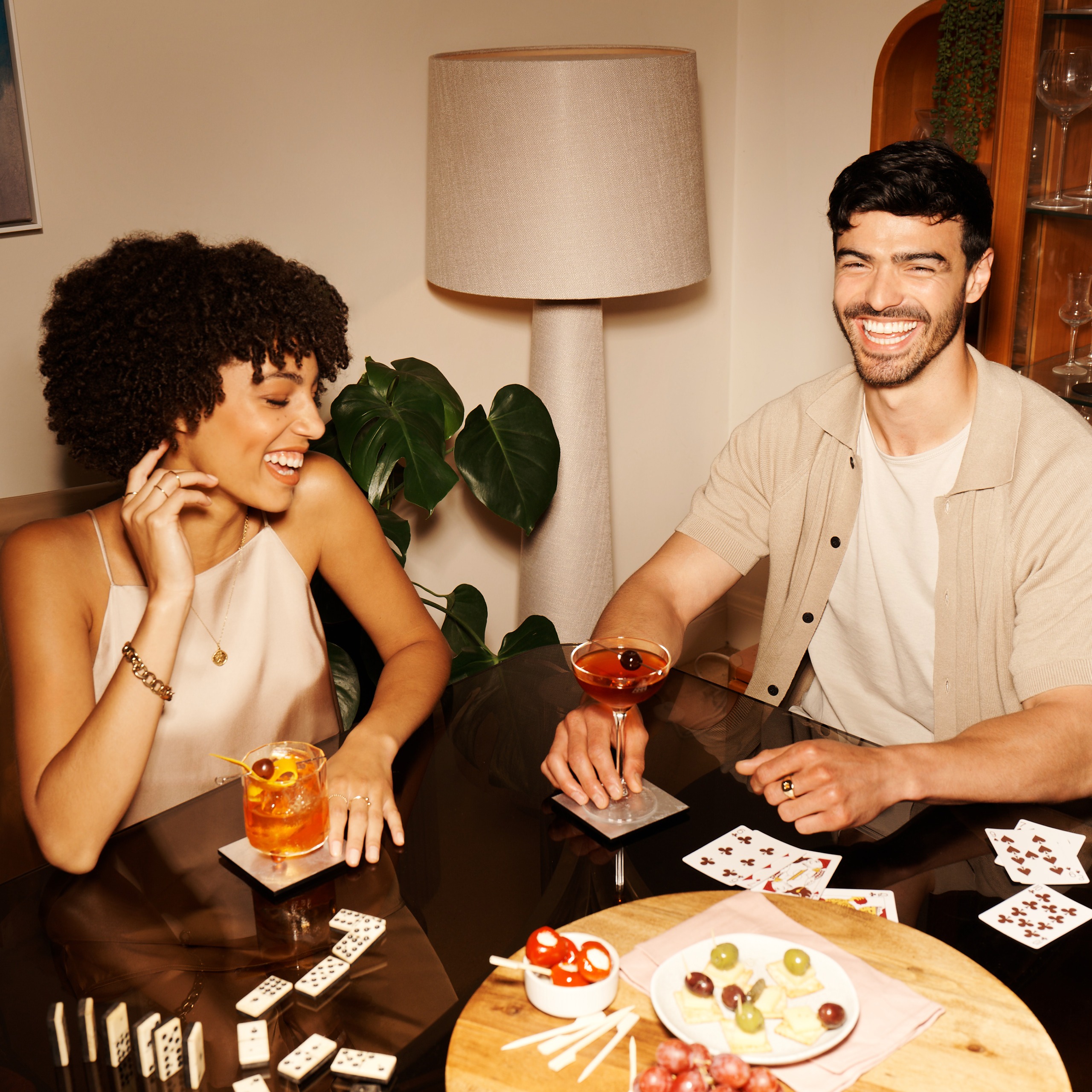 Two glasses of non-alcoholic cocktails garnished with orange slices and rosemary, placed on a light wooden table.
