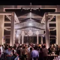En la imagen se ve el contexto del evento con una gran luz en el centro, y mucha gente presente.