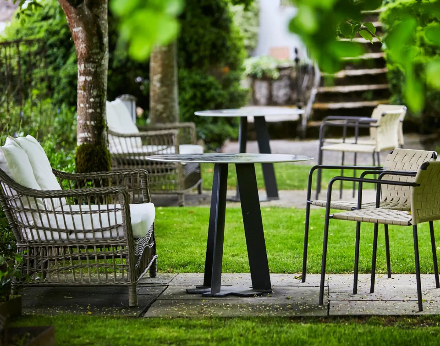 Jardín del Cenador de Amós, un espacio encantador con muebles elegantes y entorno natural, perfecto para disfrutar momentos únicos al aire libre.