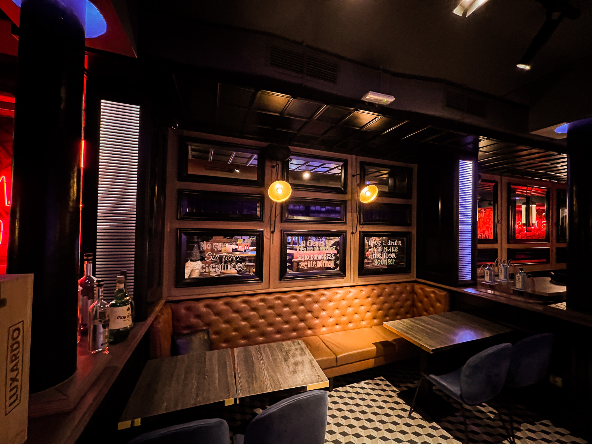 Sofás de cuero, mesas de madera y luces de neón crean un ambiente moderno y acogedor en Chester and Punk.